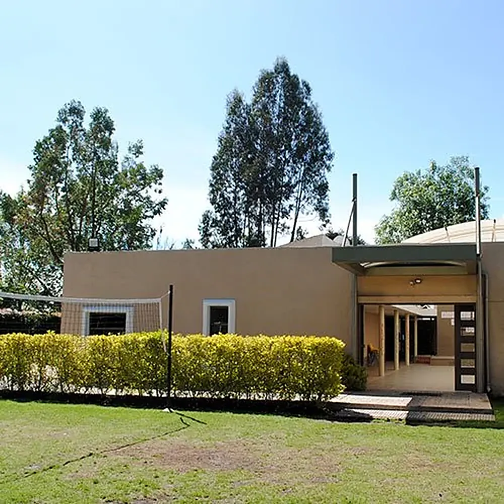 Edificio de la sede Cajicá entre el prado y los árboles