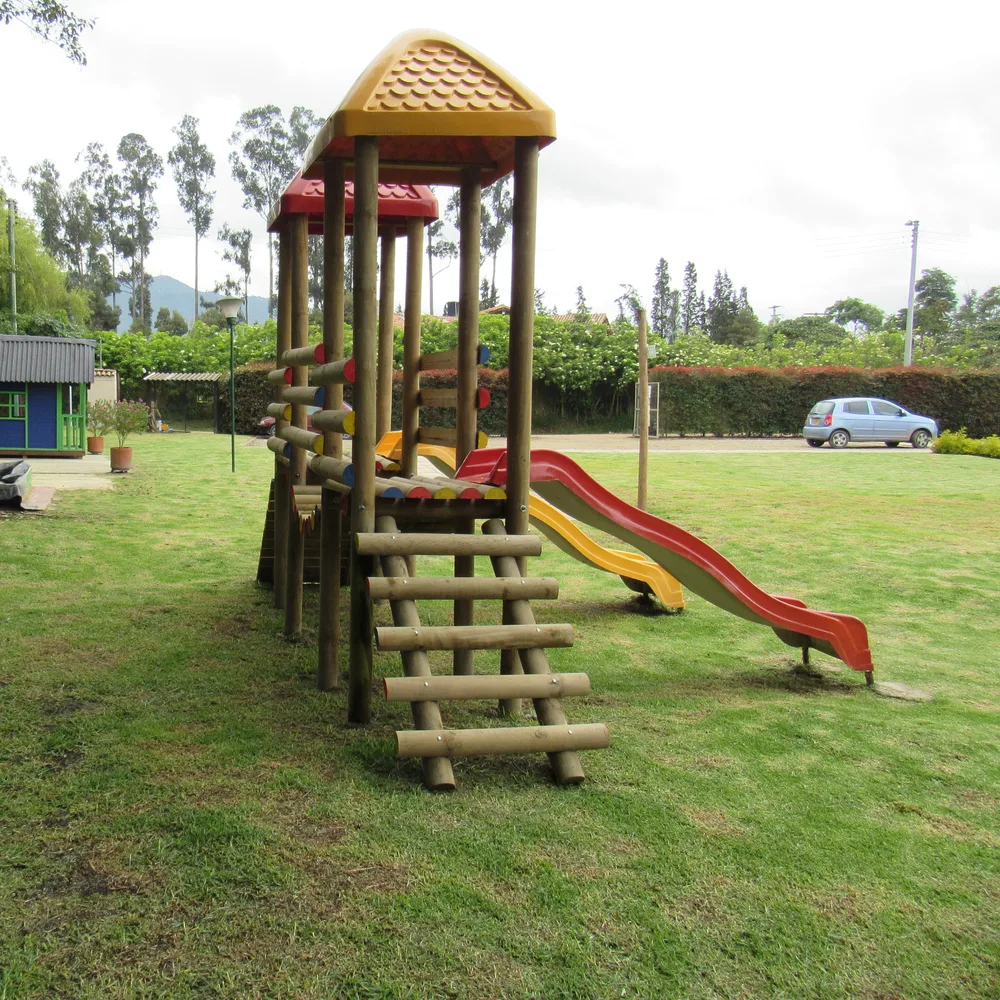 Parque de madera con rodaderos sobre el prado