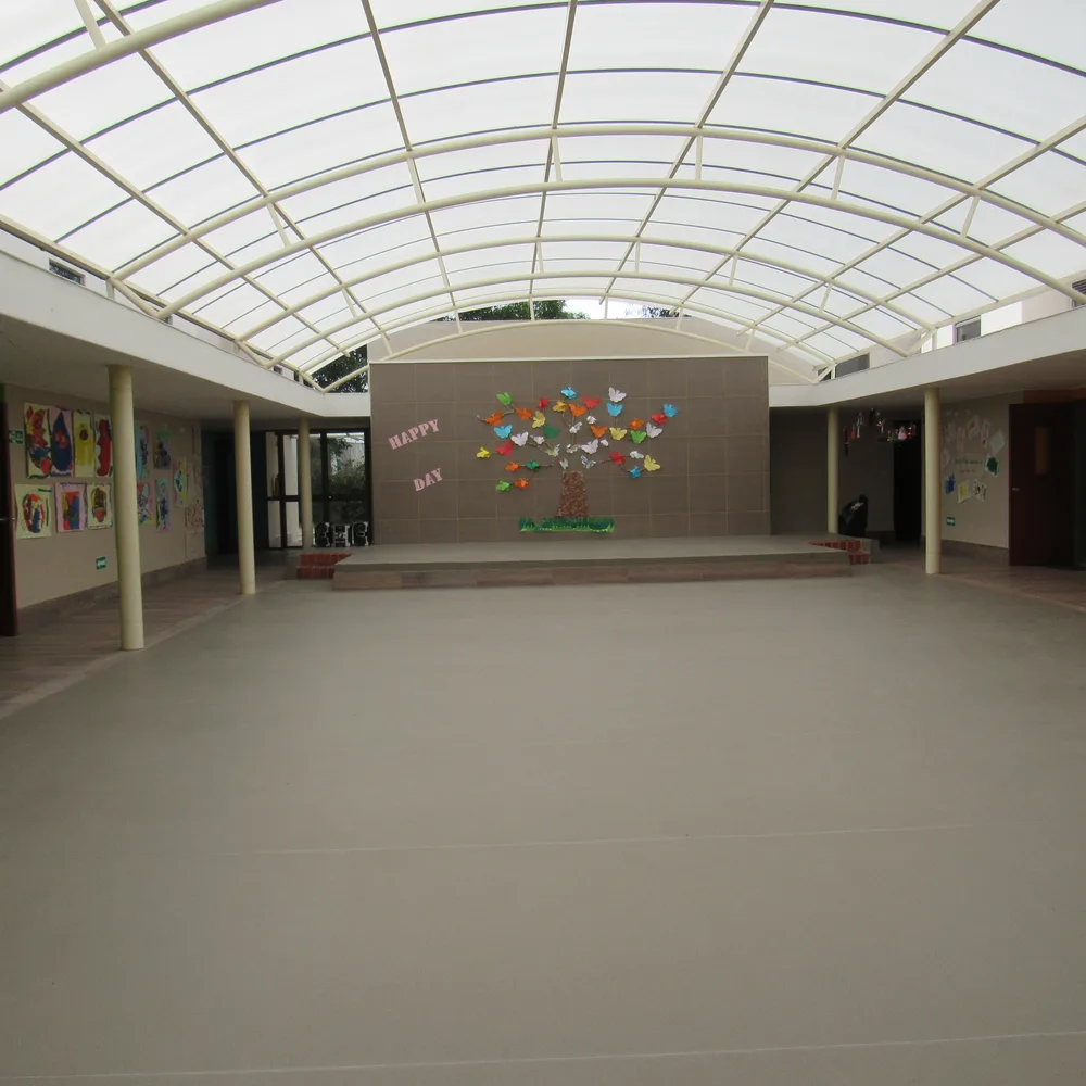 Patio cubierto de la sede Cajicá, con techo traslúcido y dibujos de los niños en las paredes