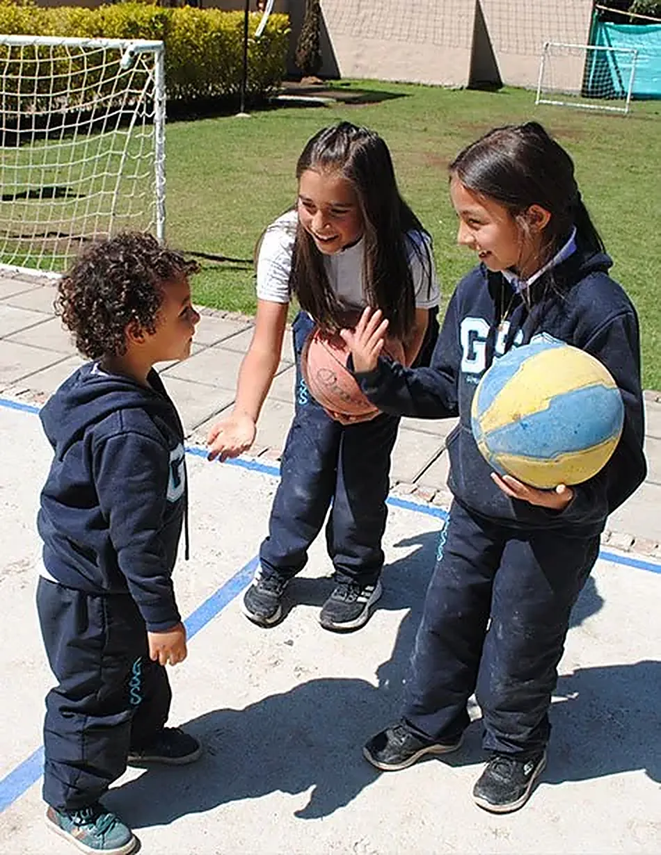 Niños de primaria con un balón en la cancha