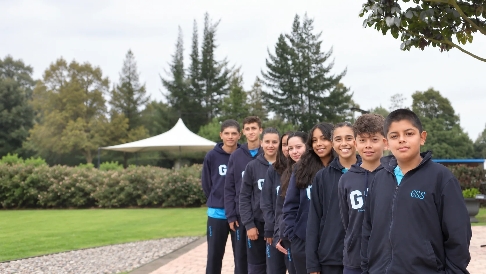 Grupo de estudiantes de secundaria del Gimnasio Santamaría de la Sabana bajo los árboles de la sede de Chía